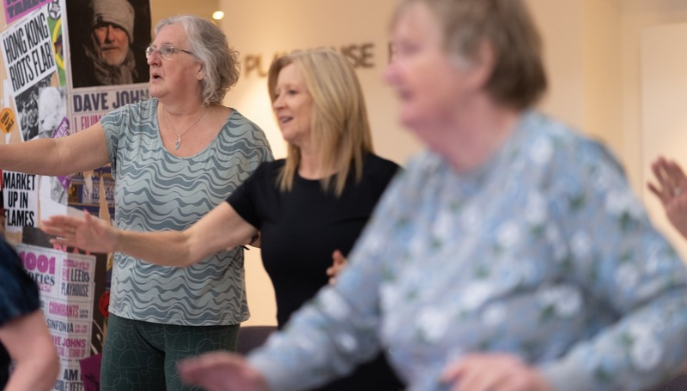 a group of 3 ladies standing exercising